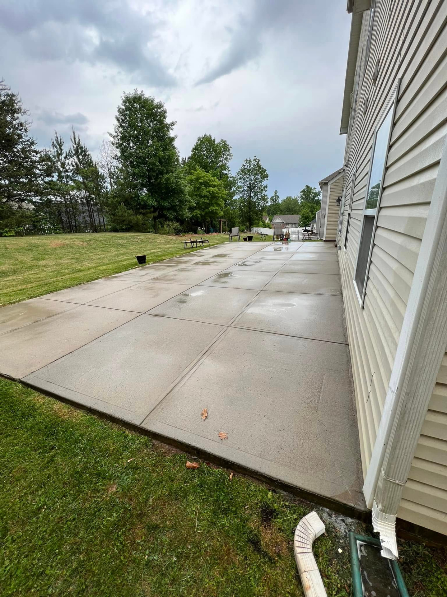 Completed concrete patio cleaning beside a residential home