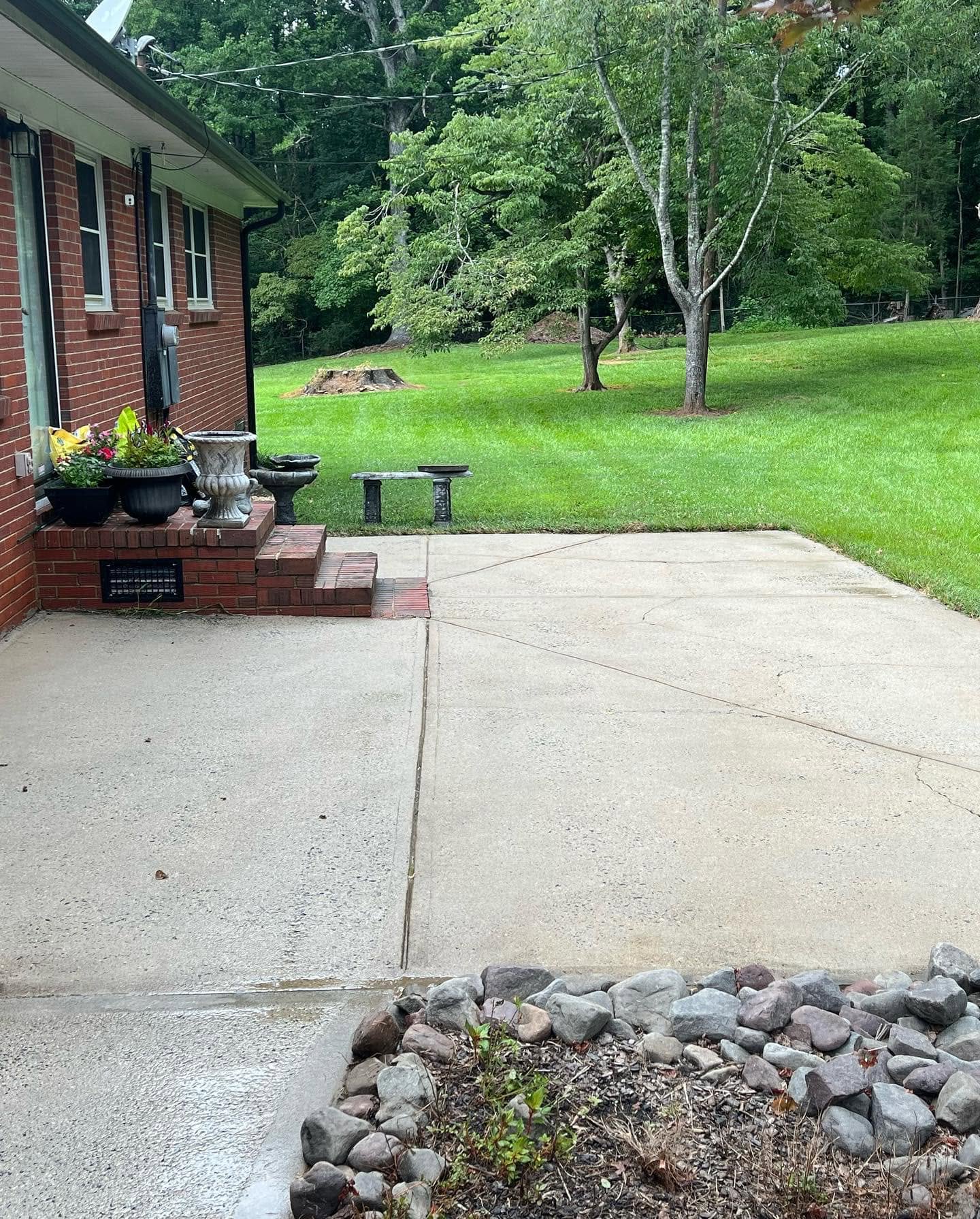 Freshly cleaned concrete beside a brick home